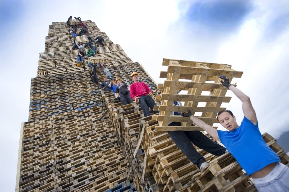 Nichts für Schwindelfreie: das Aufstapeln des Feuerholzes. In diesem Jahr soll mit 45 Metern Höhe ein neuer Weltrekord aufgestellt werden. (Foto Staale Wattø)