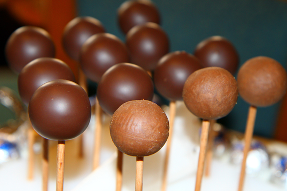 Mit Hilfe von Holzstäbchen werden die Kugeln in flüssige Schokolade getaucht. (Foto Karsten-Thilo Raab)