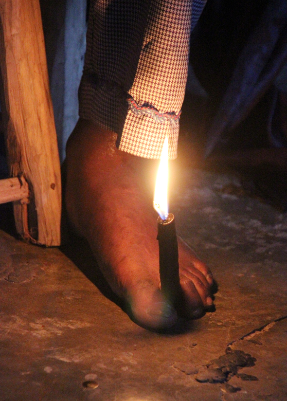 Schamane Edward hält eine Kerze mit den Zehen fest. (Foto Karsten-Thilo Raab)