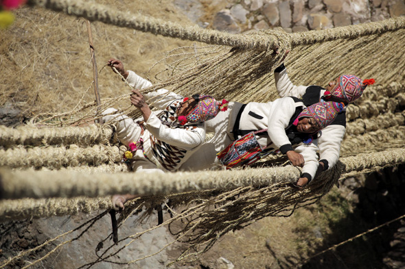 Die Inkas hängen förmlich in den Seilen, wenn sie gemäß jahrhundertealter Tradition die Hängebrücke Q’eswachaka anbringen.